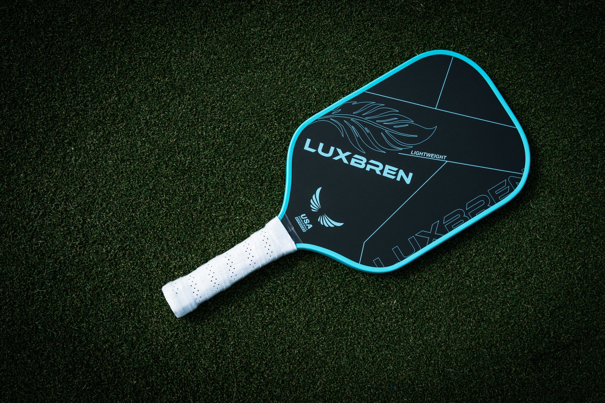 Pickleball paddle with Luxbren branding on a dark green surface